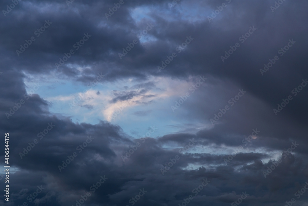 Blue sky behind dark storm clouds background texture