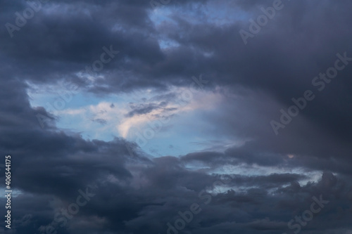 Blue sky behind dark storm clouds background texture