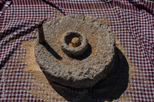 Human hand rotated ancient stone grinding machine for smashing grains. photo
