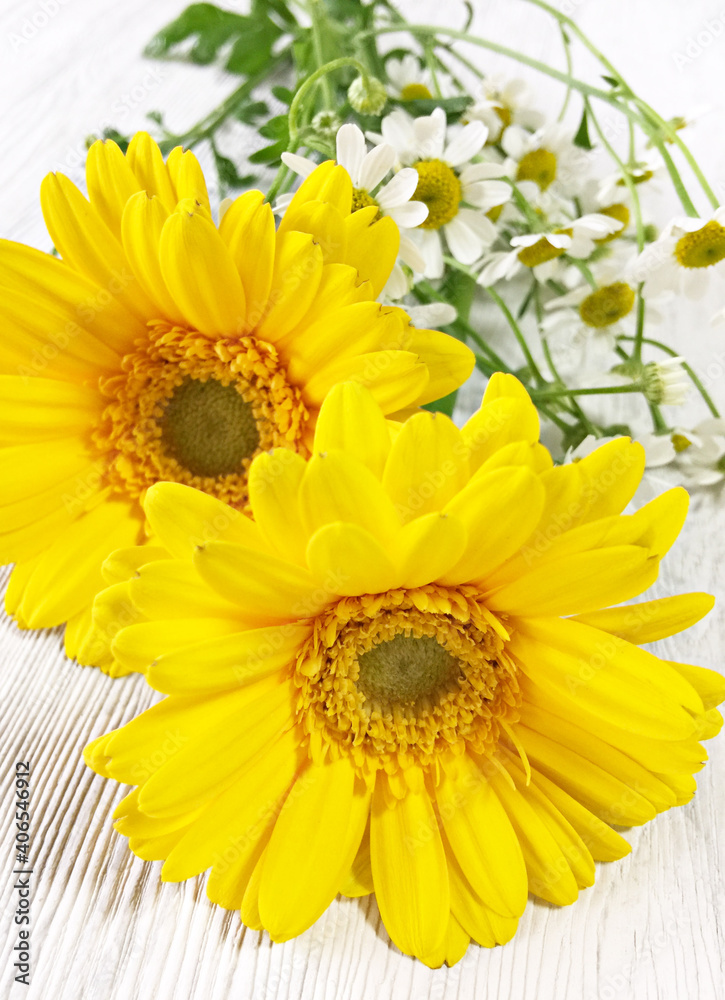 Obraz premium テーブルの上に置かれたガーベラの花とカモミール