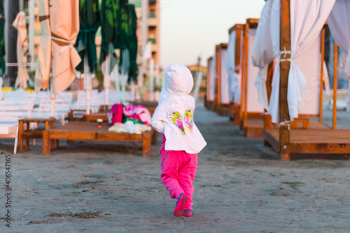 Back view of a little girlplaying at the beach photo