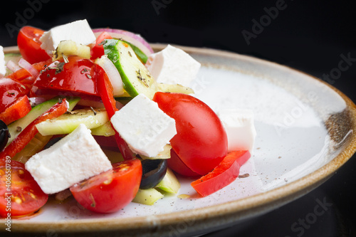 Greek salad with all cherry tomatoes, cucumber and lettuce and feta cheese, seasoned with olive oil