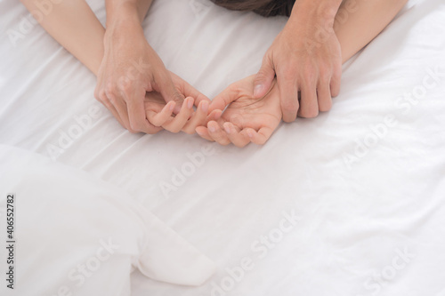 Close hands couple having sex on bed.