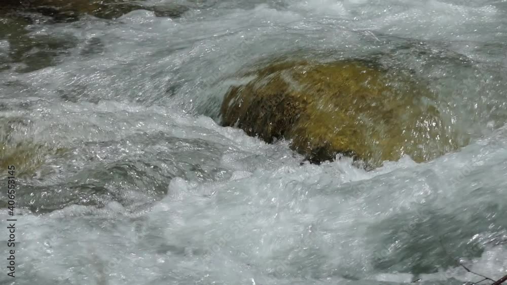 Ecology. Water. Pure natural water formed by the melting of the glacier runs in a transparent stream between the stones in the sunlight. Siberia, Altai. Ecology. Water. Pure natural water formed by the melting of the glacier runs in a transparent stream between the stones in the sunlight. Siberia, Altai.