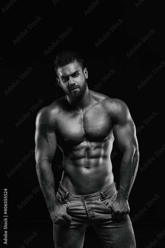 Male fitness model Konstantin Kamynin posing shirtless on black background Male fitness model Konstantin Kamynin posing shirtless on black background
