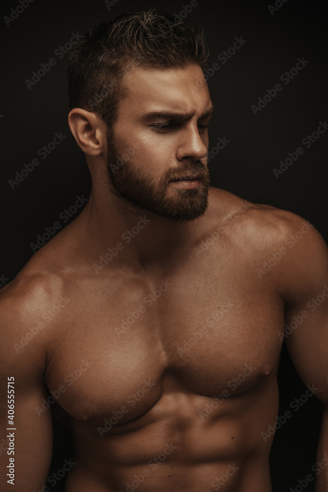 Fitness model Konstantin Kamynin portrait on black background