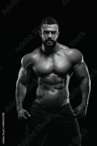 Fitness male model standing on black background