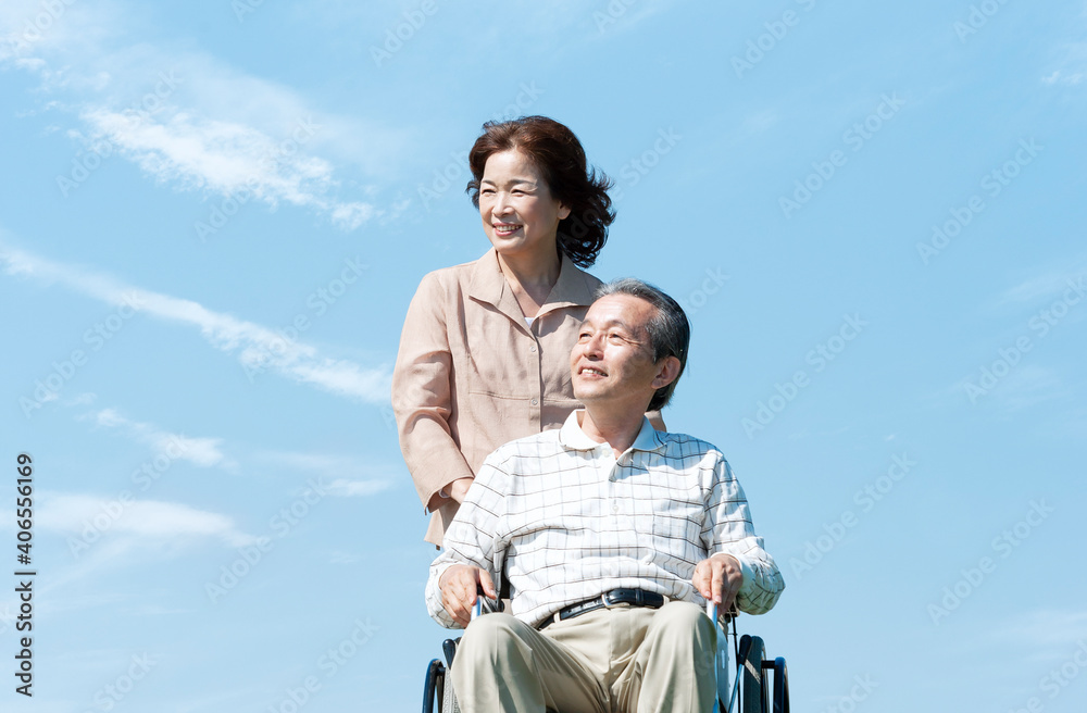 車椅子で散歩するシニア夫婦 車椅子で散歩するシニア夫婦