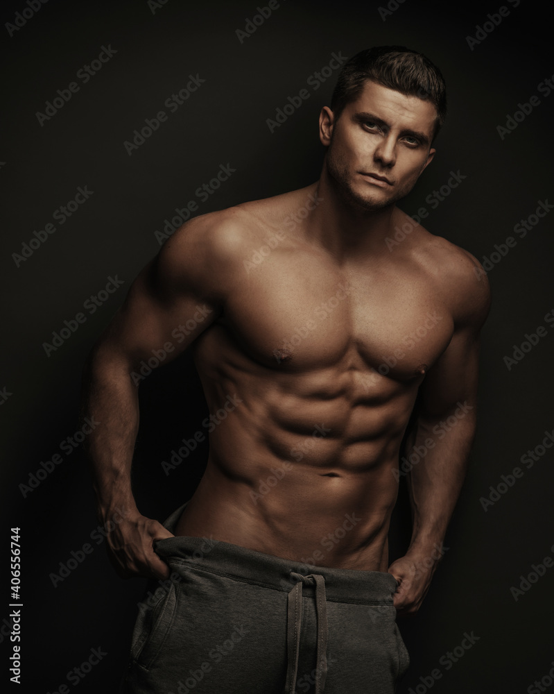Fitness male model in sport pants at black background Fitness male model in sport pants at black background