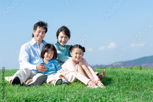 芝生に座る家族 © UTS
