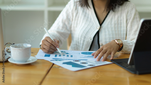 Female office worker analysing business document on wooden worktable
