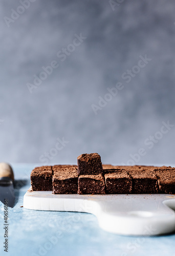 Chocolate ganache truffle squares dusted with cacao on a cutting board photo