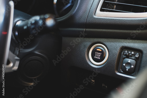 Close up of start and stop engine button in the eco car built into the console. Nowadays, newer cars can use a hand start button, which is more modern and comfortable.