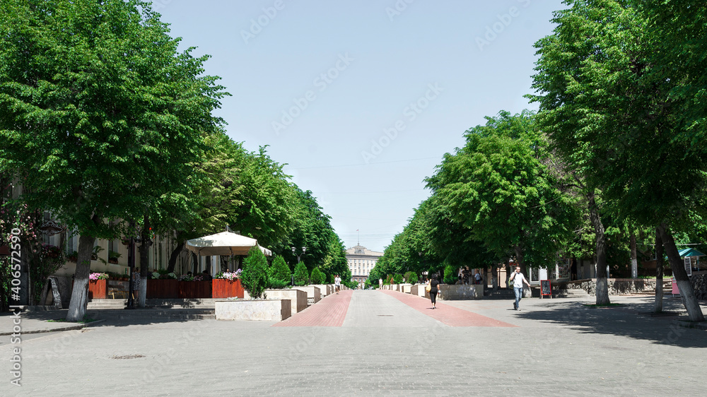 The town of Oryol, Russia, the main pedestrian street in summer, green trees, cafes and shops, walking people.
