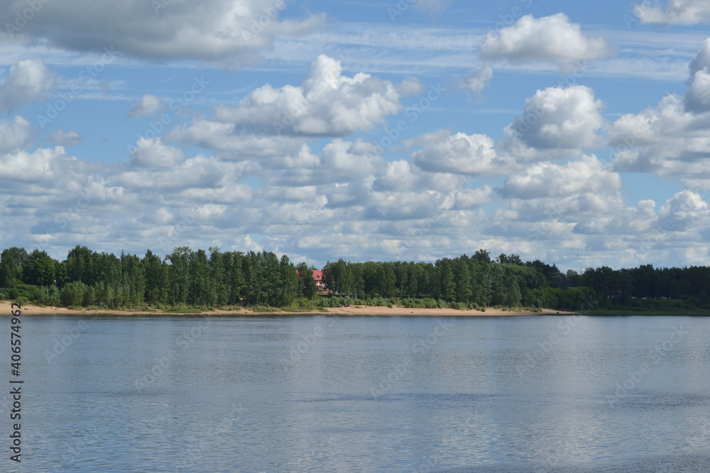 Summer landscape with a river and fluffy white clouds in the sky. Rybinsk, Russia, Volga river. Summer landscape with a river and fluffy white clouds in the sky. Rybinsk, Russia, Volga river.