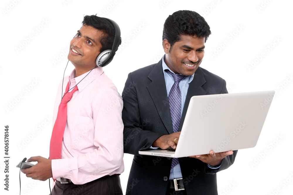 Obraz premium Two indian business people, one is working other one is listening music on white.