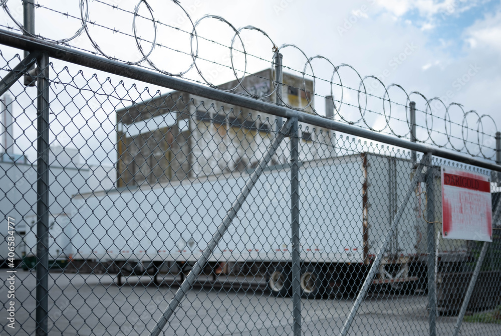 Industrial building behind barbed wire fence. Industrial building behind barbed wire fence.