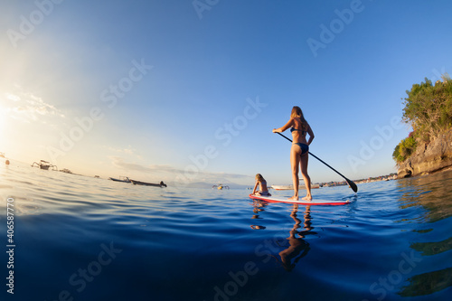 Canvas Print Active paddle boarder at sunset sea
