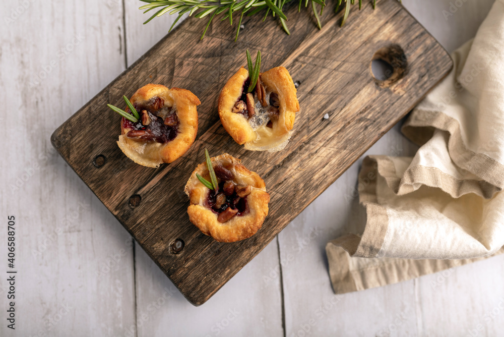 Fototapeta premium Brie bites with jam and nuts in crescent dough, mini appetizer dessert with cranberry or any jelly