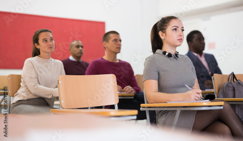 .Multiethnic group of people studying together at table . Focus on ukrainian woman