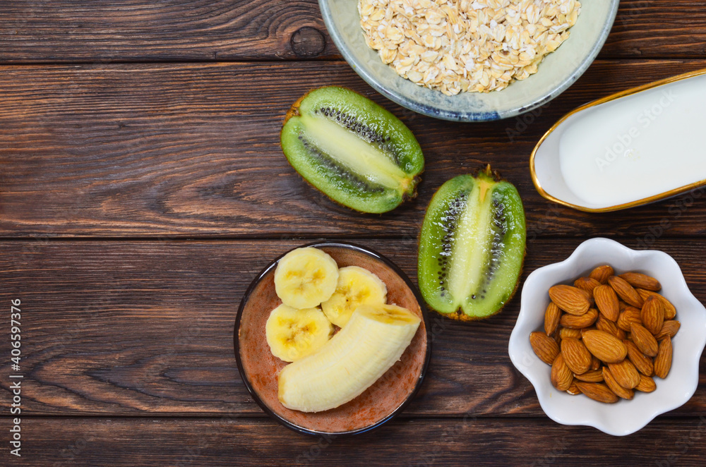 Ingredients for making milk porridge, oatmeal, milk, banana, kiwi top view, healthy food and hearty breakfast with fruits