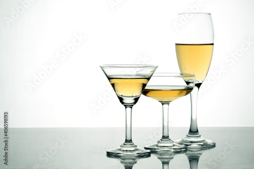 Glasses of alcohol drinks on white.