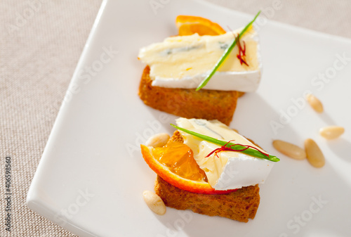 Canape with slice of orange and blue cheese Queso blando y azul