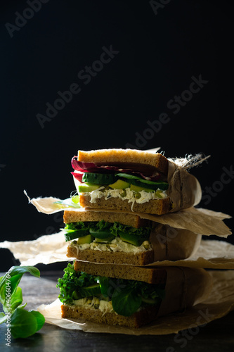 Vegetarian sandwich with fresh cucumber, avocado and corn salad leaves