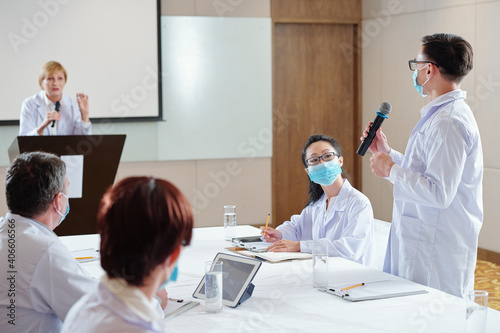 Researcher with microphone asking speaker about work princple of new vaccine she is presenting at conference photo