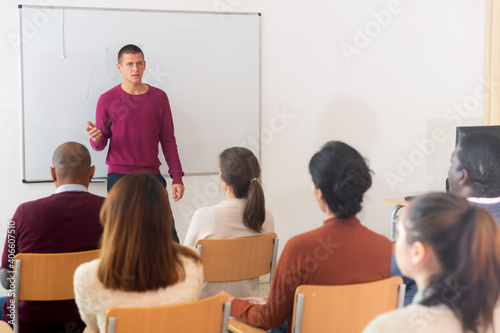 Teacher at university in front of chalkboard with multinational students