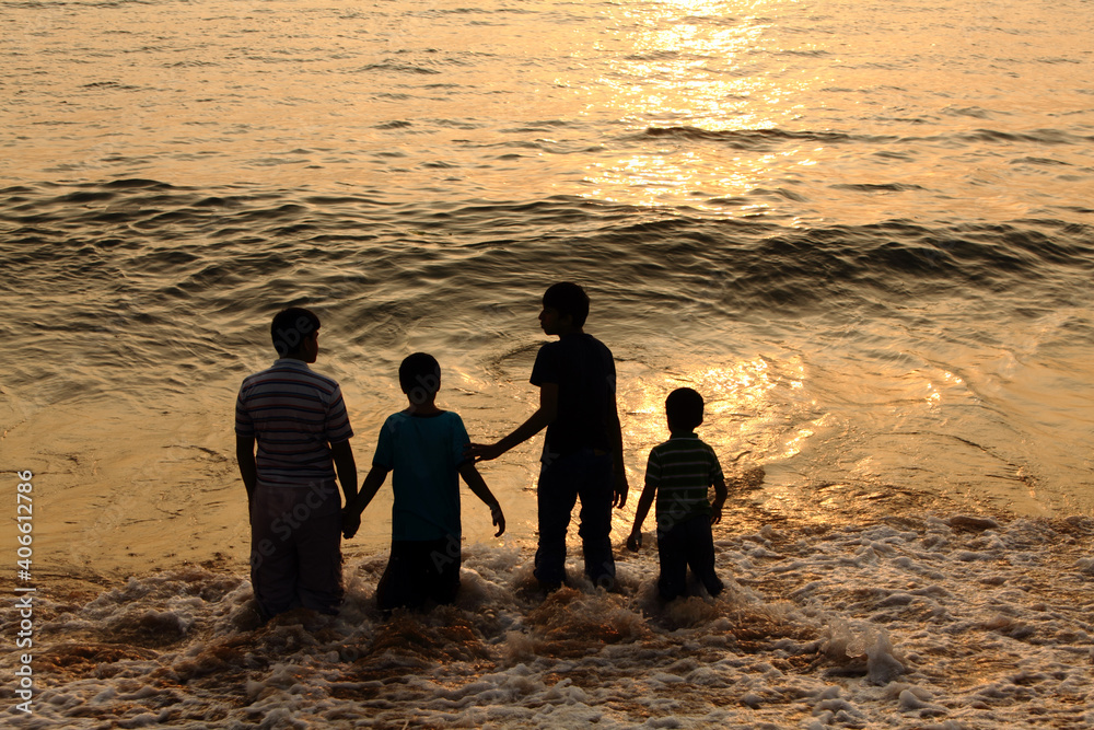 Group of young boys playing in sea water taken with  silhouette