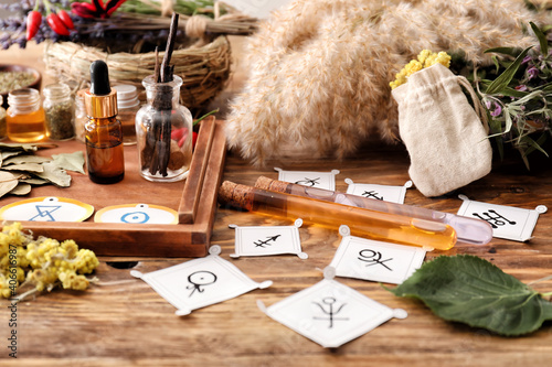 Alchemical symbols and ingredients for preparing potions on wooden background