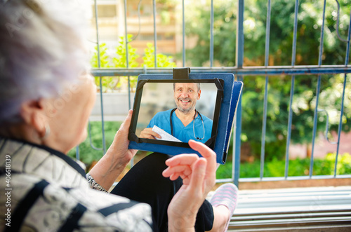 A senior adult female patient connects with a geriatric doctor through a telemedicine application.