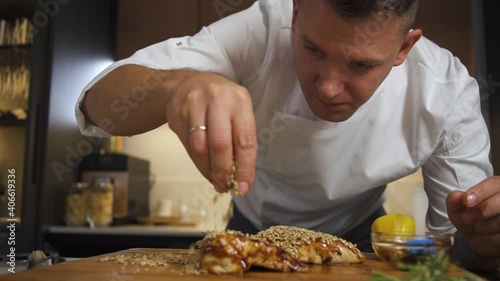 Professional Chef Adding Finishing Touches to Elegant Festive Meat Meal In Restaurant Kitchens. Chef Preparing Serves Dish For Catering Service In Cafe Eatery. Man Cooking Delicious Food In Kitchen.