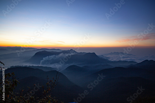 Sunrise over the mountains standing in fog on the island of Sri Lanka. © Oleg