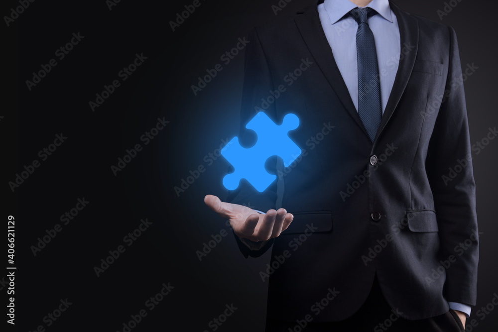 Businessman holds a piece of puzzle jigsaw in his hands.The concept of cooperation, teamwork, help and support in business. Businessman holds a piece of puzzle jigsaw in his hands.The concept of cooperation, teamwork, help and support in business.