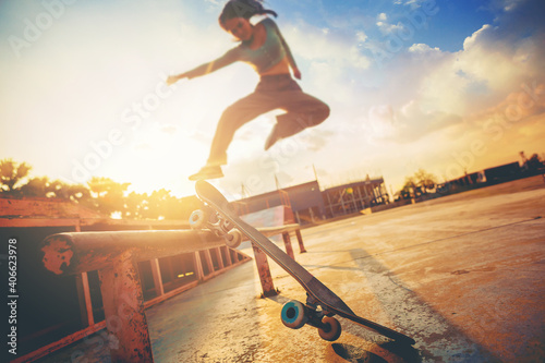 Foto Young woman practising skateboarding at skate park