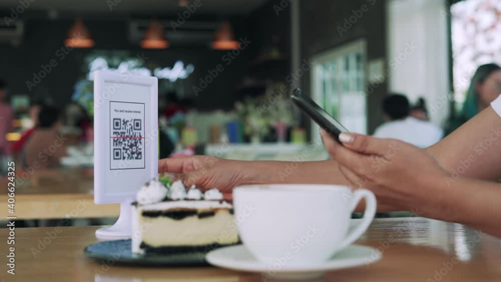 Women's hands are using  the phone to scan the qr code to select food menu. Scan to get discounts or pay for food. The concept of using a phone to transfer money or paying money online without cash.