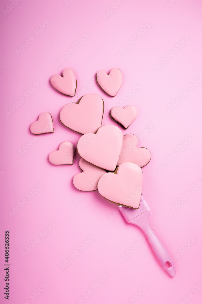 Creative flat lay Valentines concept composition. Paint brush made with hearts on pink background with copy space. Spring or wedding anniversary invitation card, template or mock up.