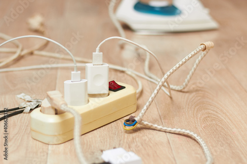 Foto The extension cord and iron are lying on the floor with a large current consumption