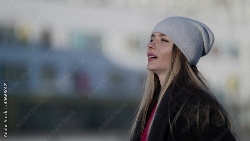 Portrait of a fashionable young smiling blonde woman in a coat and hat walking and posing on a city street. Autumn, winter fashion. Portrait of a fashionable young smiling blonde woman in a coat and hat walking and posing on a city street. Autumn, winter fashion.