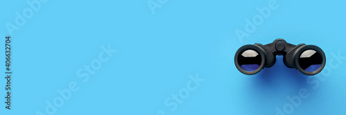 Binoculars on a light blue background. Banner. Flat lay, top view