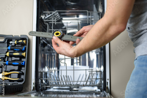 handyman repairs dishwasher © penyushkin