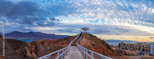 Panorama. Scenic point of view on the Red Sea and vicinity of desert area, decorative public pergola on top and safe walkway to the stone summit, Middle East