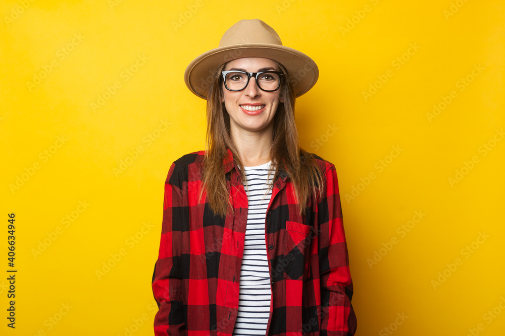 Young woman in hat and plaid shirt on yellow background Young woman in hat and plaid shirt on yellow background