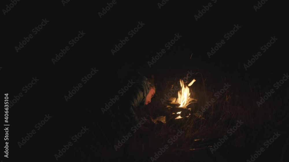 Man inflamed bonfire in wilderness at night after exhausted hike in the mountain,close up shot. Man inflamed bonfire in wilderness at night after exhausted hike in the mountain,close up shot.
