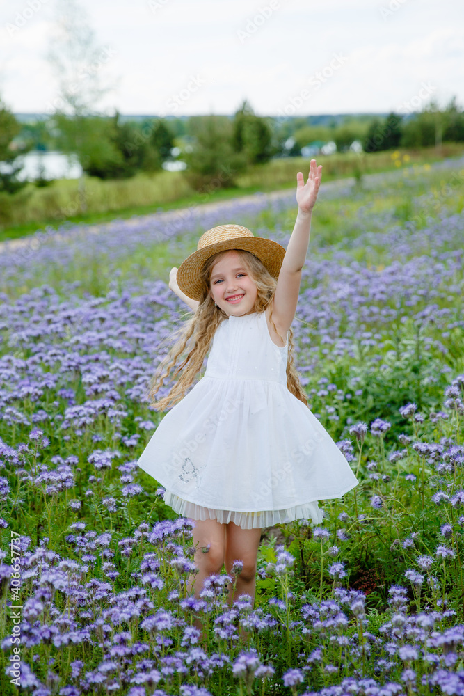 little girl in a straw hat in a purple field in summer little girl in a straw hat in a purple field in summer