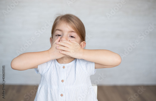 Little girl closing her mouth with hands. Childhood trauma, traumatic experience. Psychological assistance, children rescue. Silent cry for help. photo