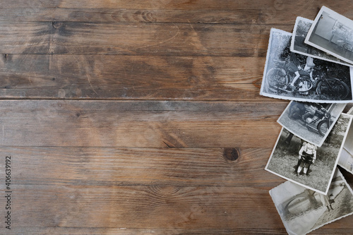 stack of old vintage monochrome photographs on photographic paper on natural wood background, concept of genealogy, memory of ancestors, family tree, nostalgia, childhood, remembering photo