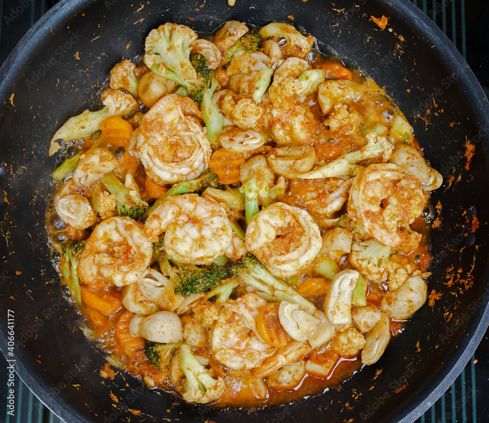 Close up Thai spicy stir fry vegetables and shrimps with spicy red curry paste on a pan, Top view of Thai spicy food Close up Thai spicy stir fry vegetables and shrimps with spicy red curry paste on a pan, Top view of Thai spicy food